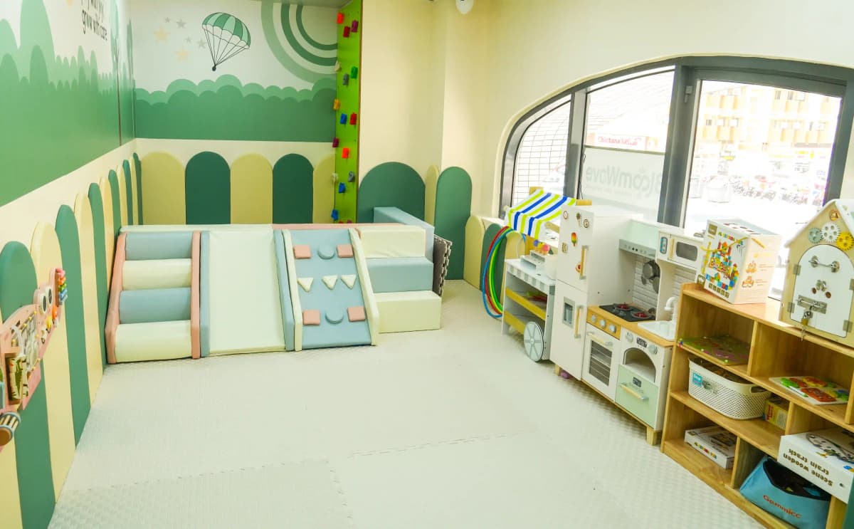 Indoor play area with climbing equipment and pretend-play toys at BloomWave